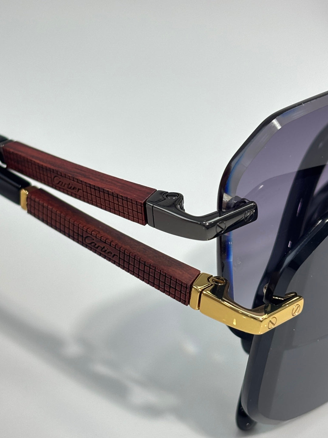 Cartier eyeglasses temple close-up with red textured grip, black tips, gold-tone hinge