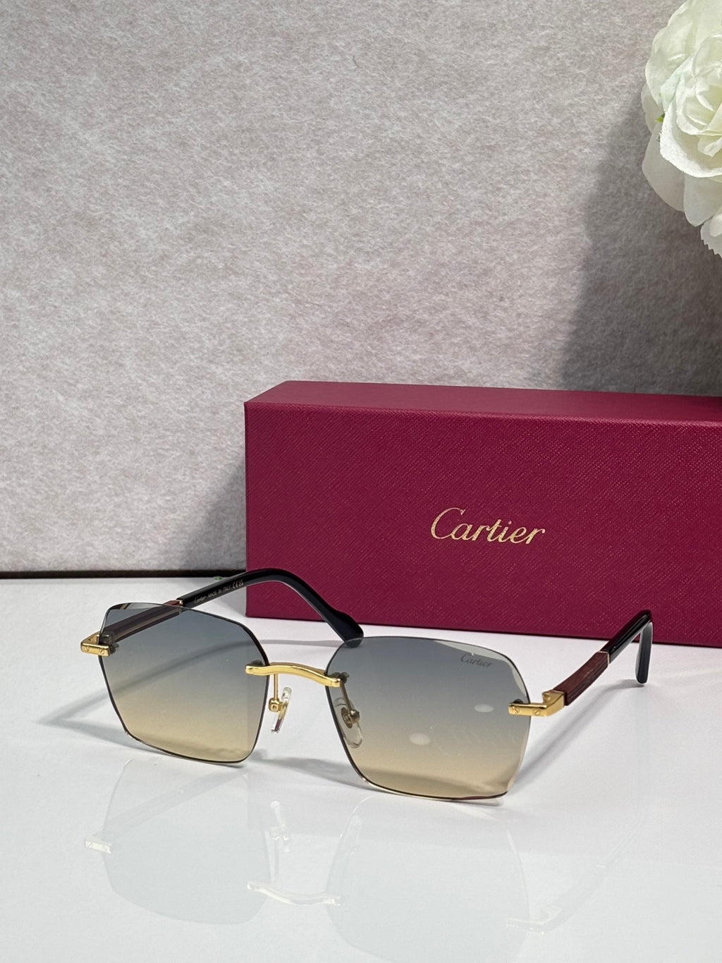 Cartier sunglasses with amber-tinted lenses, dark frame, and gold metal accents.