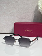 Cartier sunglasses with dark grey lenses, black frame, and gold metal accents.