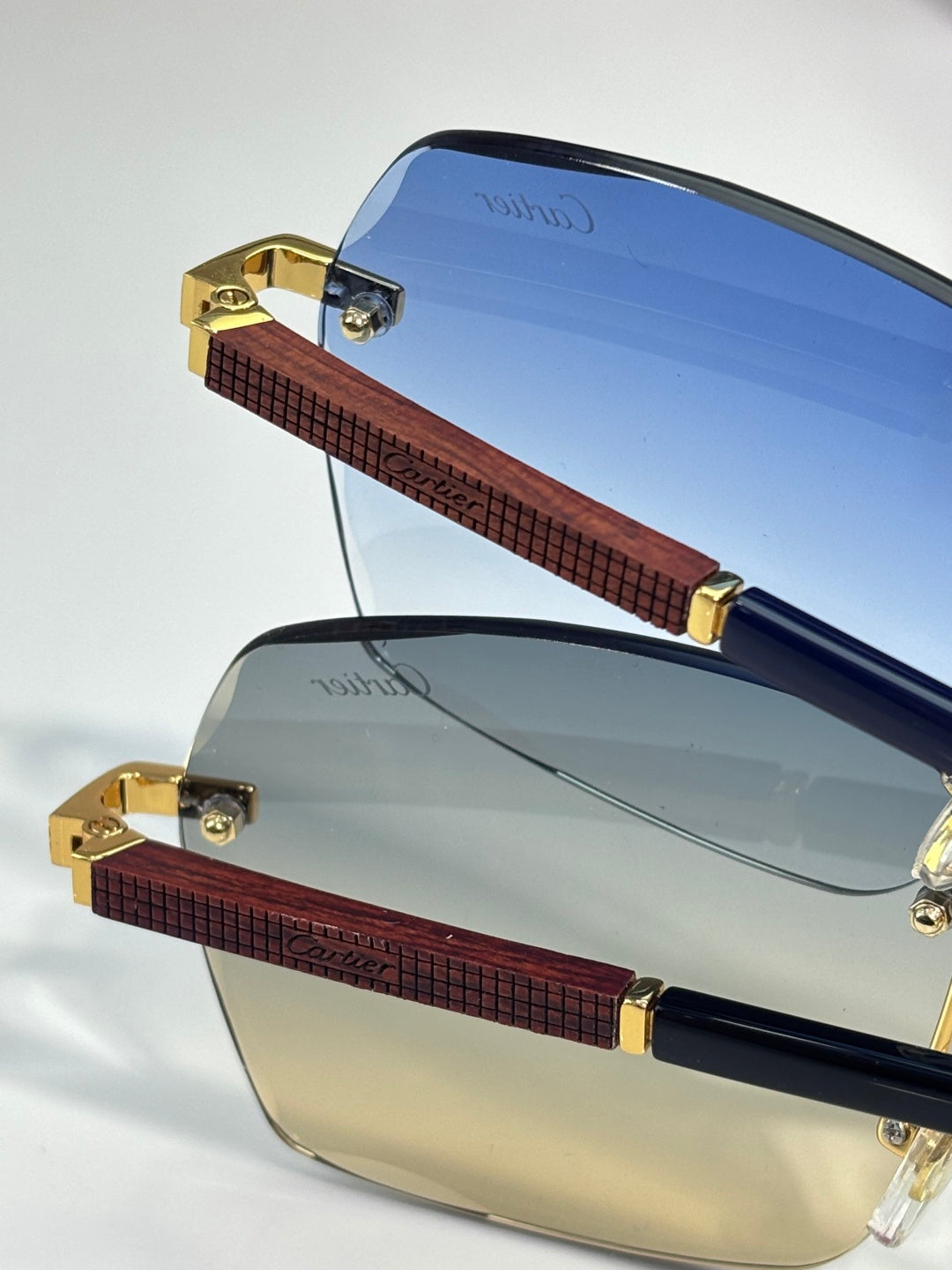 Cartier sunglasses close-up: blue gradient lenses with brown textured bridge and gold parts.