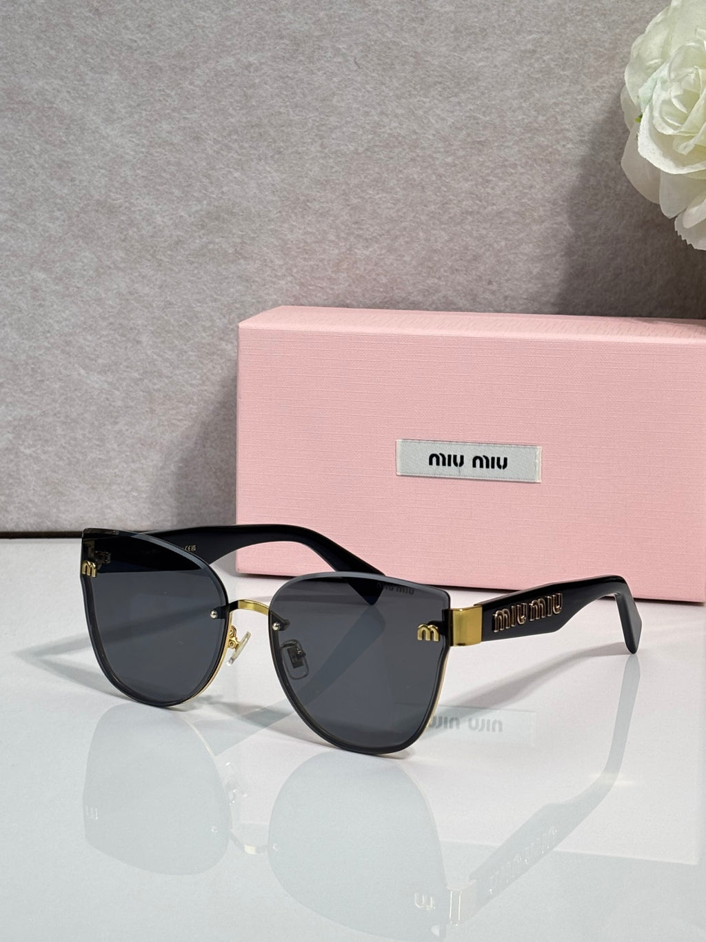 Black cat-eye style glasses with dark gradient lenses and gold-tone hardware