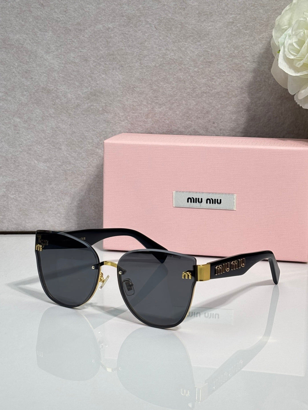 Black cat-eye style glasses with dark gradient lenses and gold-tone hardware