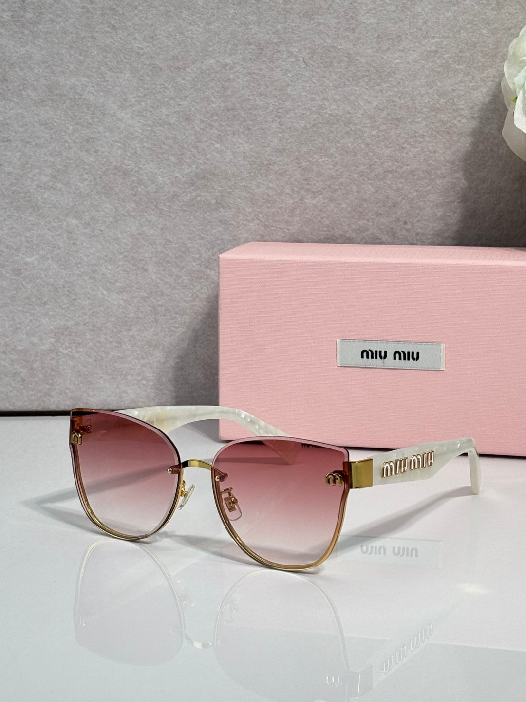 Round glasses with burgundy gradient lenses, pale frames, and gold-tone metal details