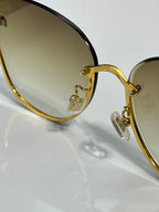 Gold-tone round glasses hinge and temple detail with translucent frame sections