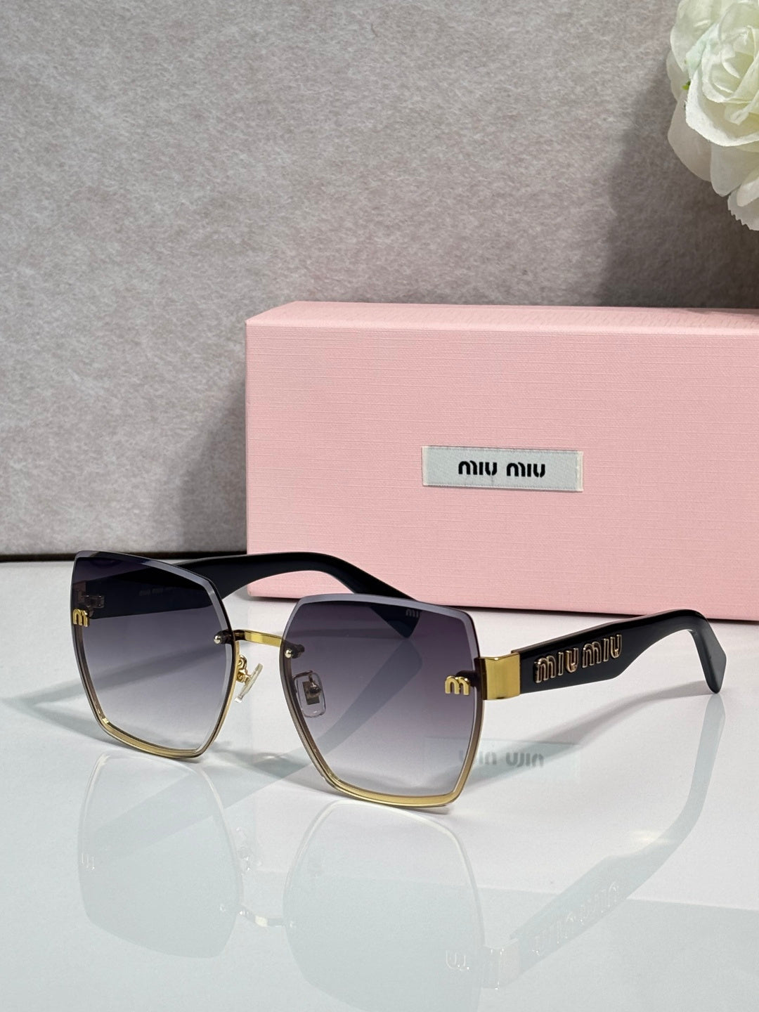 MiuMiu cat-eye sunglasses with dark tinted lenses and gold-tone metal details, side view