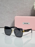 MiuMiu cat-eye sunglasses with dark smoke lenses and gold-tone metal arms