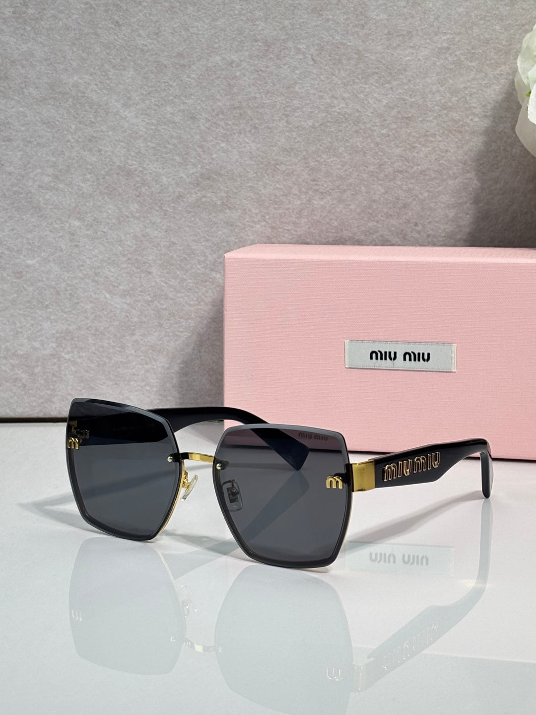 MiuMiu cat-eye sunglasses with dark smoke lenses and gold-tone metal arms