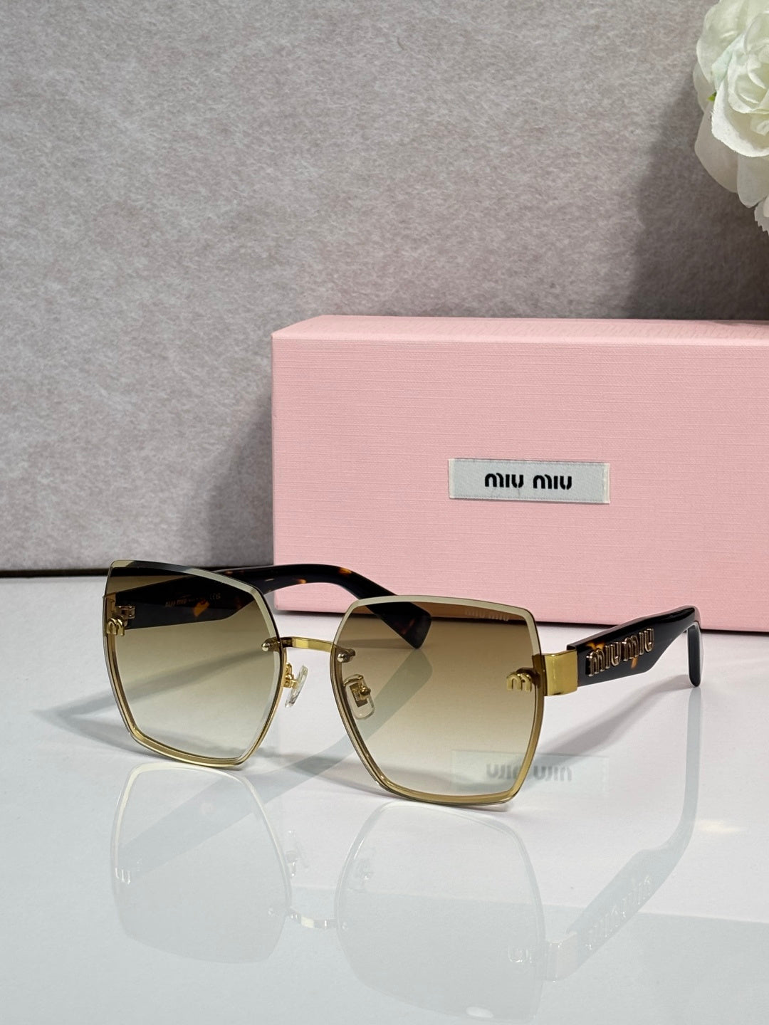 MiuMiu cat-eye sunglasses with light amber lenses and gold-tone metal frame