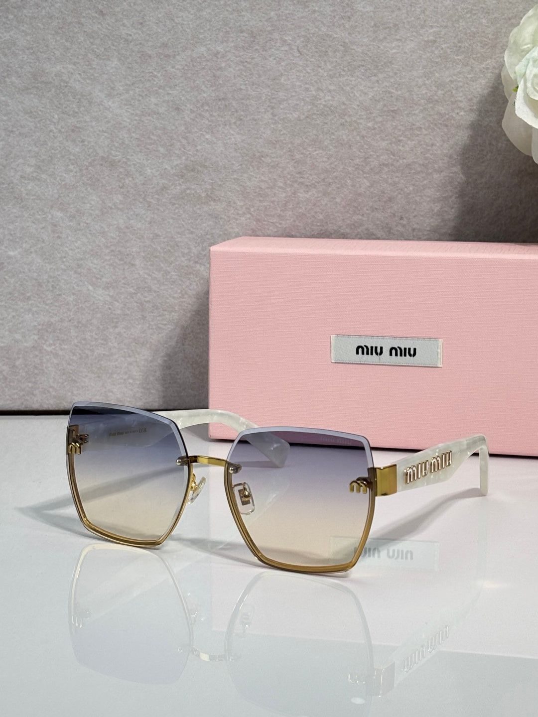 MiuMiu cat-eye sunglasses with pale gradient lenses and gold-tone metal frame