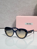 MiuMiu black round sunglasses with gold logo temples and dark lenses