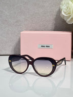 MiuMiu black round sunglasses with gold logo temples and mirrored dark lenses