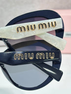 MiuMiu navy round sunglasses with gold logo temples and dark lenses