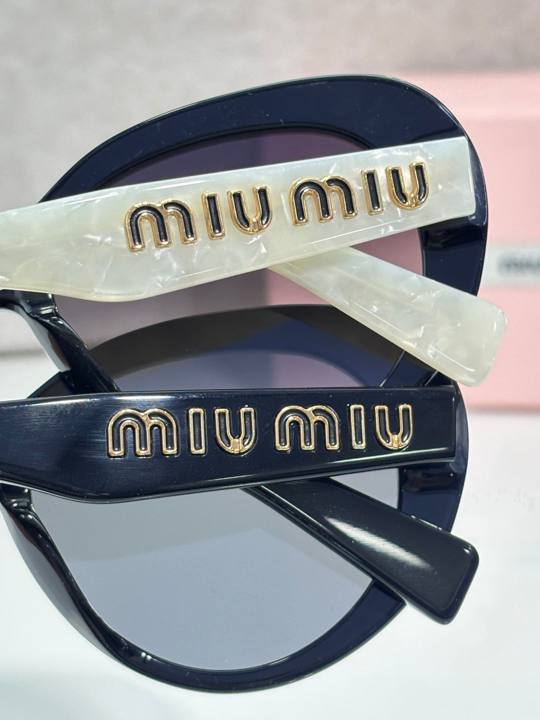 MiuMiu navy round sunglasses with gold logo temples and dark lenses