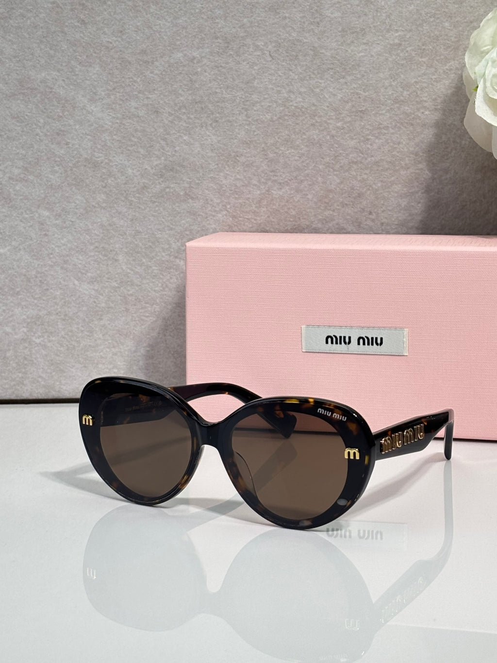 MiuMiu black round sunglasses with tortoise patterned arms and dark lenses
