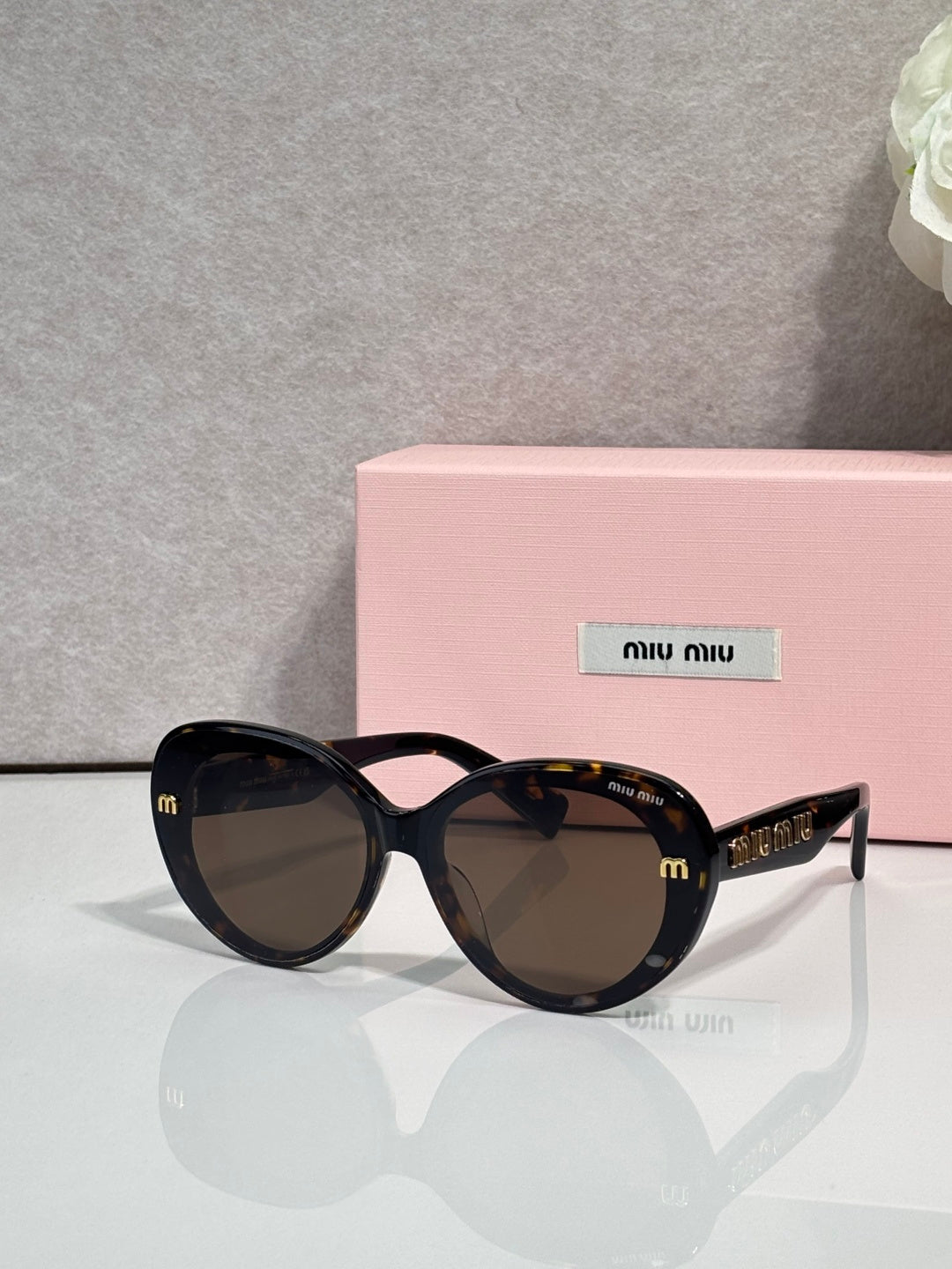 MiuMiu black round sunglasses with tortoise patterned arms and dark lenses