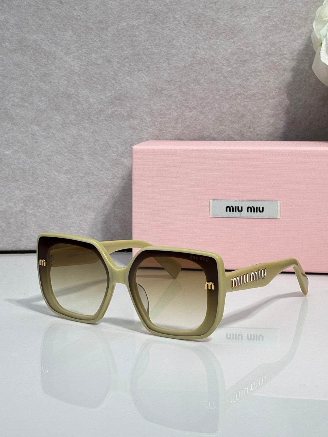 Square sunglasses with pale green frames and dark lenses