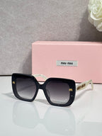 Square sunglasses with black frames and pale green temple arms