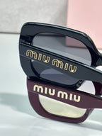 Two-tone sunglasses close-up with navy top frame and burgundy bottom