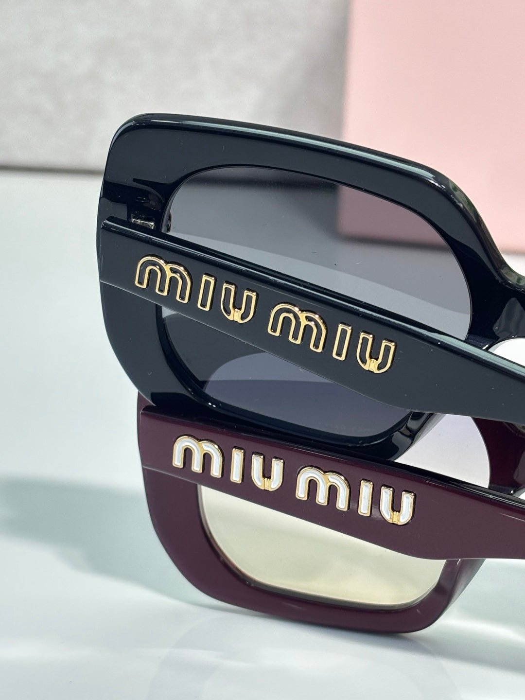 Two-tone sunglasses close-up with navy top frame and burgundy bottom