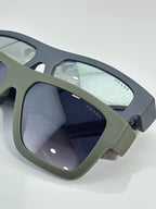 Camo sunglasses close-up: dark lenses with Prada marking on arm.