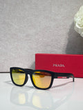 Prada sunglasses with black frames and yellow-tinted lenses, PRADA logo at temple