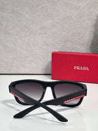 Prada sunglasses with black frames and dark lenses, folded cross-angle