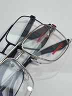 Prada eyeglasses with clear lenses and metal frame, red logo stripe on black temple.