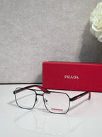 Prada eyeglasses with clear lenses and black rectangular frame, red temple logo accents.