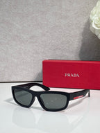 Prada sunglasses with black rectangular frames and dark gray tinted lenses