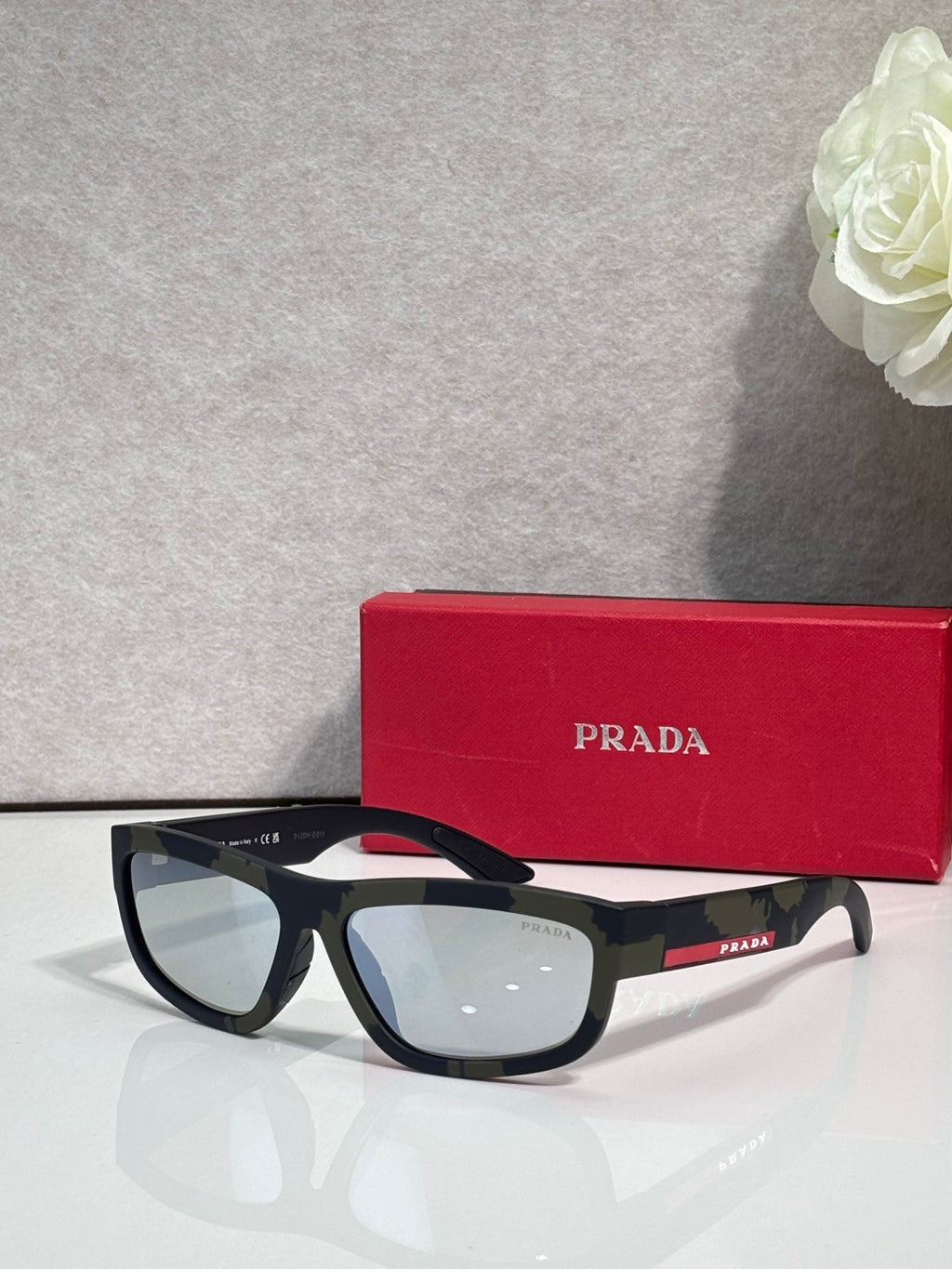 Prada sunglasses with black rectangular frames and light gray tinted lenses