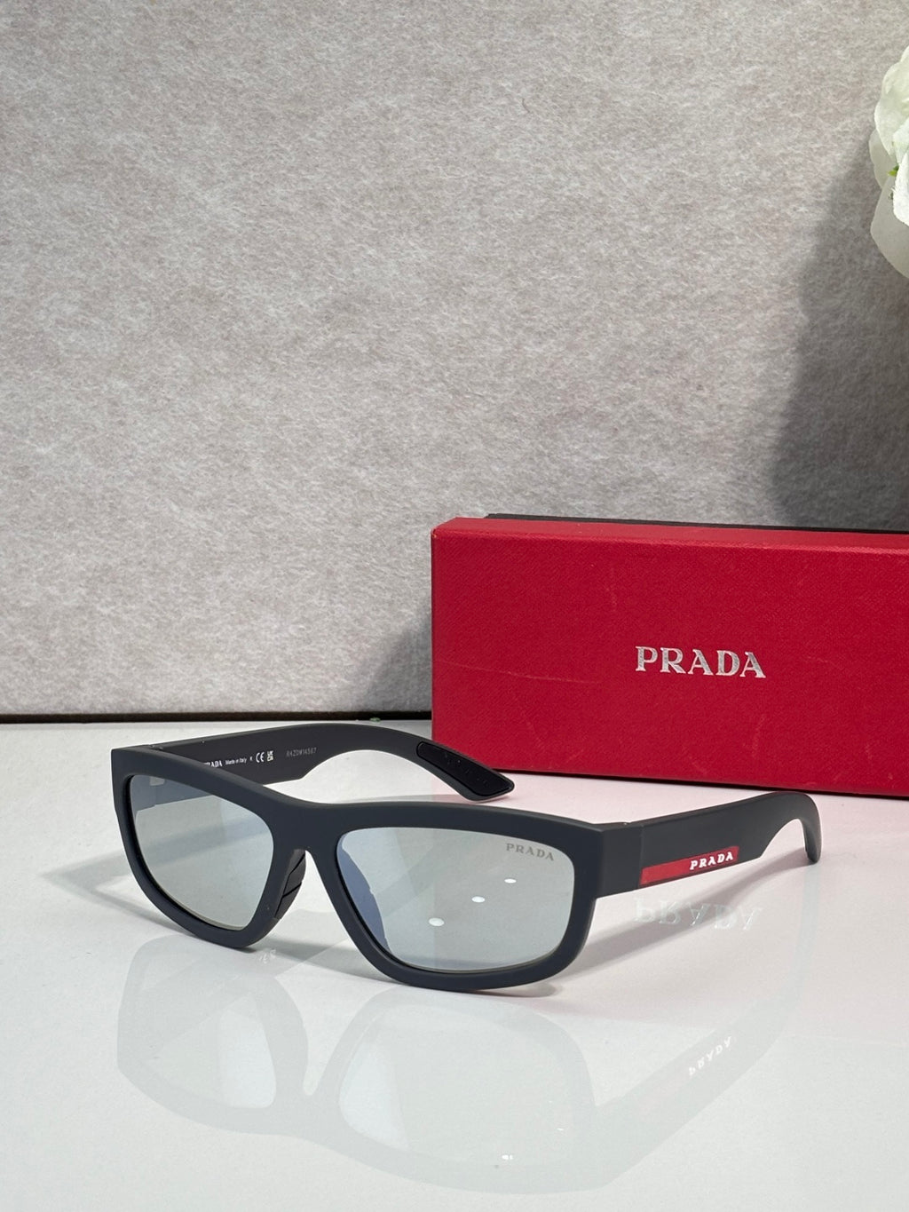 Prada sunglasses with black rectangular frames and light gray tinted lenses