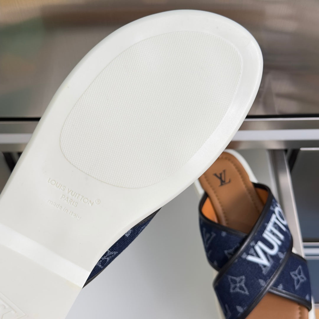 White outsole of Louis Vuitton slide sandal with navy monogram strap