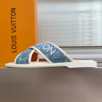 Louis Vuitton slide sandals with blue monogram upper and white footbed, side view