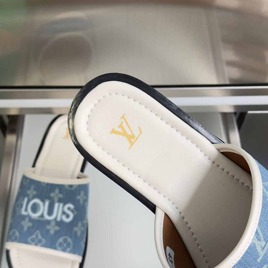 Louis Vuitton slide sandal close-up with blue monogram strap and gold LV logo