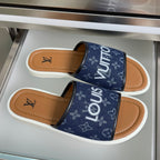Louis Vuitton slide sandals, navy monogram straps, tan footbed, white sole