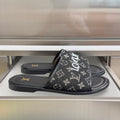 Louis Vuitton monogram slide sandals in black with wide front strap and flat sole