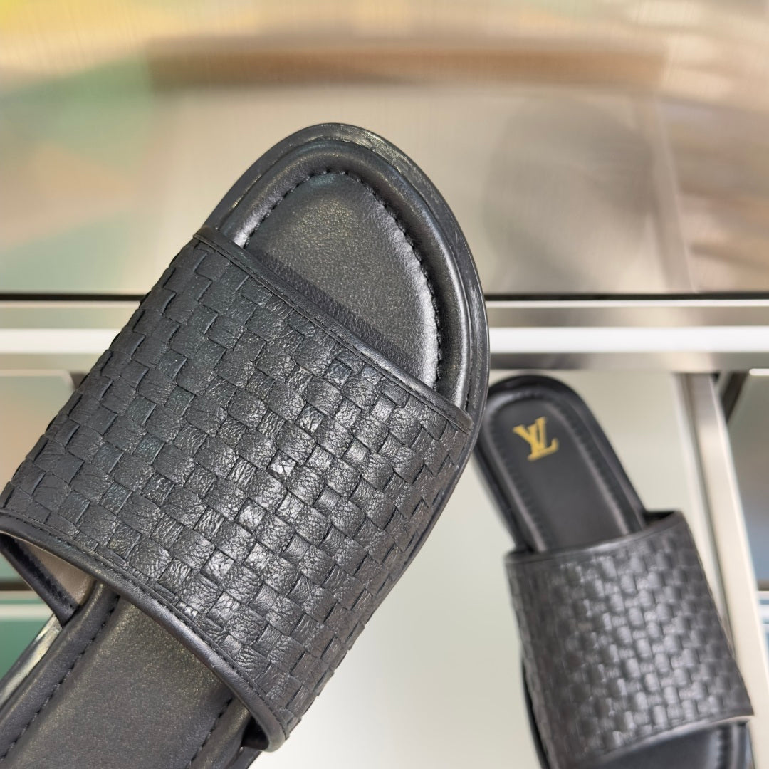 Black woven leather slide sandals with thick padded straps and smooth outsole