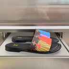 Black Louis Vuitton slide sandals with multicolor knit strap and gold LV logo