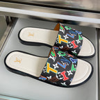 Louis Vuitton slide sandals with black patterned strap and white footbeds