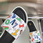 White strap slide sandal with multicolor monogram letters over a black footbed