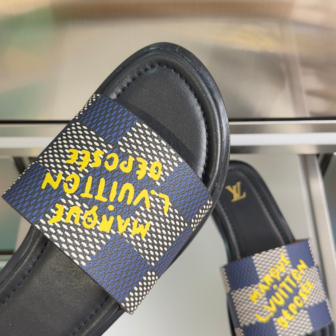 Louis Vuitton slide sandal close-up, blue check strap with yellow text-like print