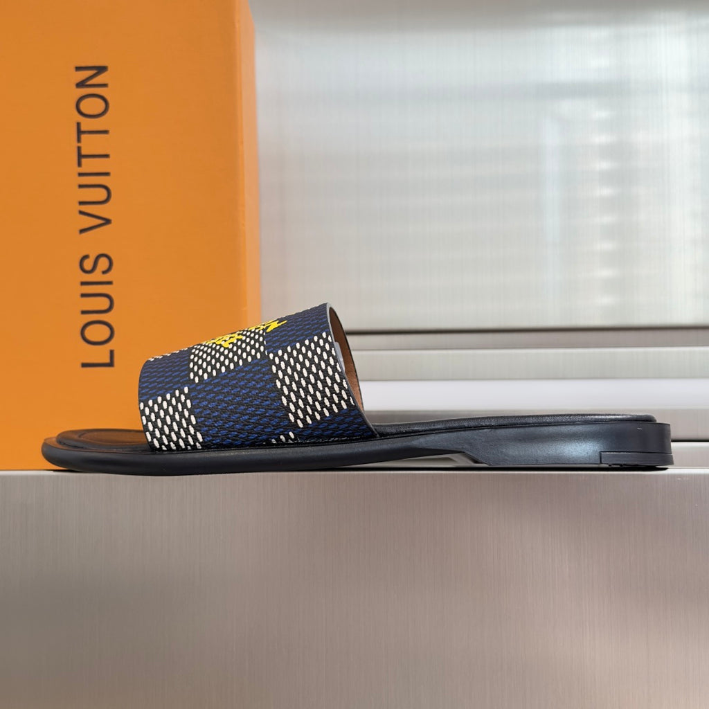 Louis Vuitton slide sandal, side view, black sole with blue check strap and yellow logo