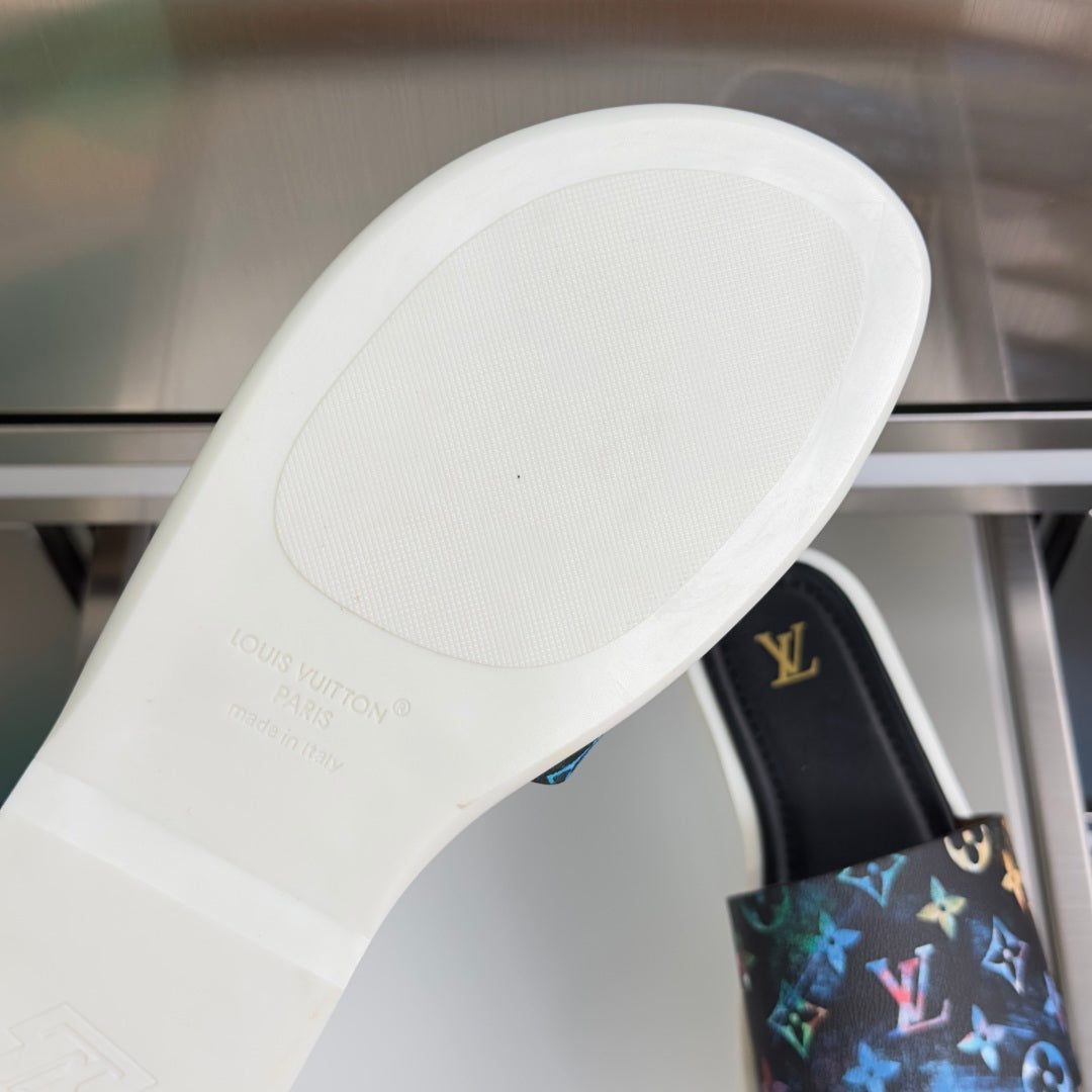 Louis Vuitton white rubber outsole with brand text, with black slide sandal beside it