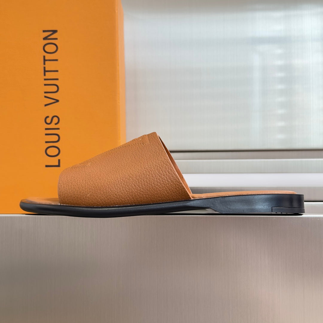 Tan leather slide sandal with wide strap and flat rubber sole, LV logo