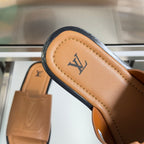 Tan leather slide sandal strap with embossed LV mark and stitched edge