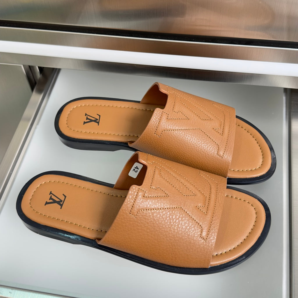 Tan leather slide sandals with wide strap and embossed LV on footbed