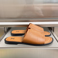 Louis Vuitton leather slide sandals in tan, with engraved LV logo on strap