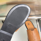 Tan leather slide sandal with textured rubber outsole and brand stamp on sole