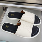 Louis Vuitton slide sandals, white straps with gold LV emblems, black footbeds