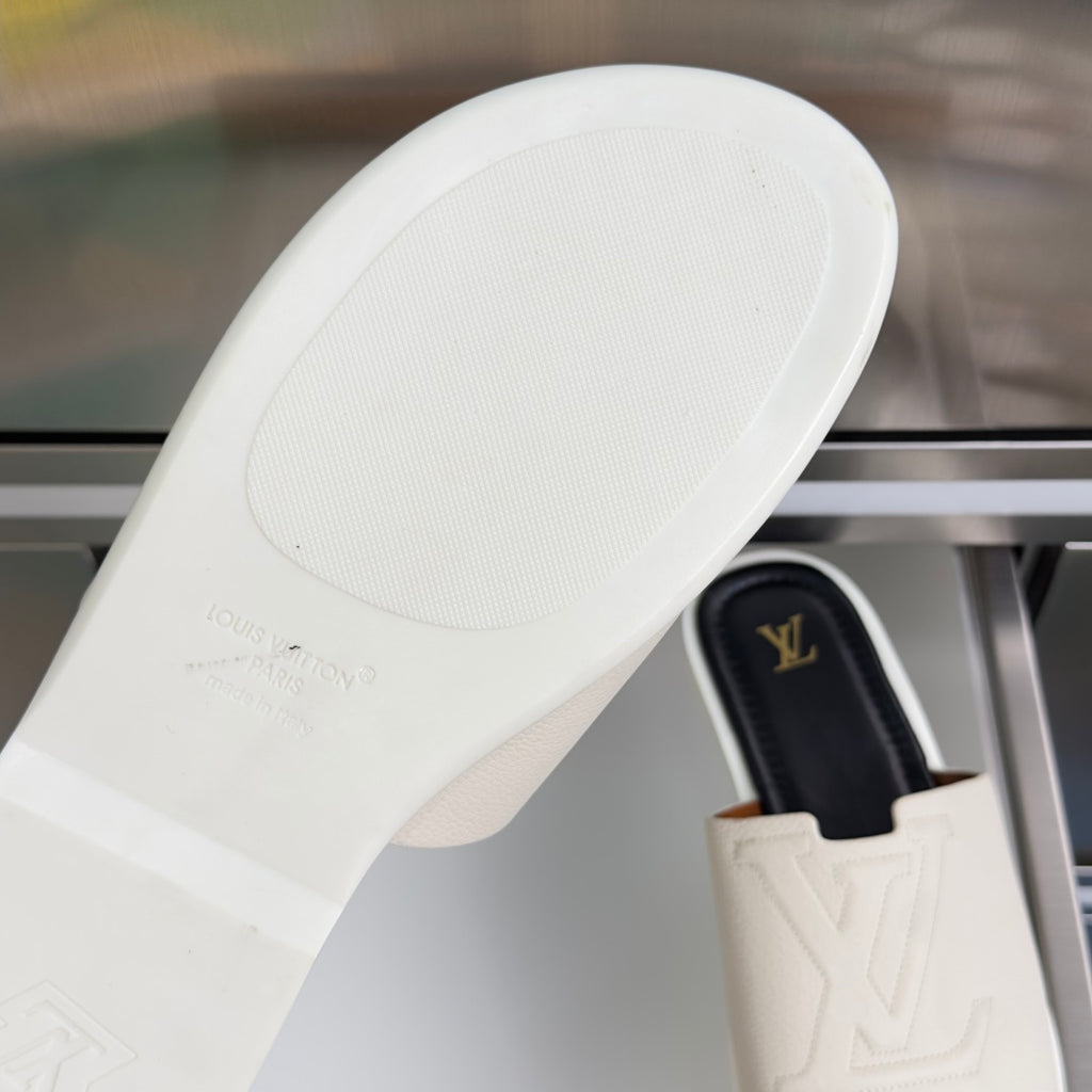 Louis Vuitton slide sandal sole close-up, white textured rubber with small logo